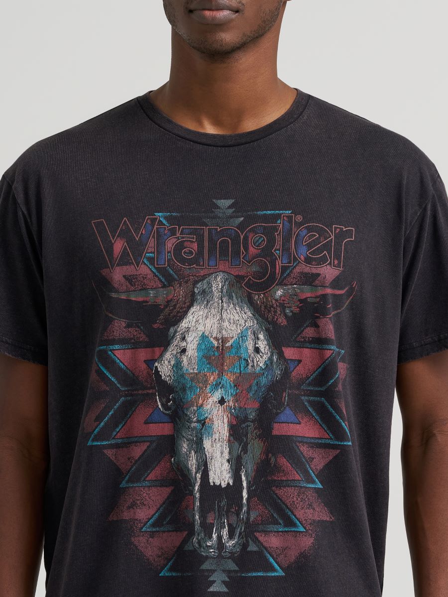 Man wearing a black Wrangler tshirt with a cow skull on it on a grey background