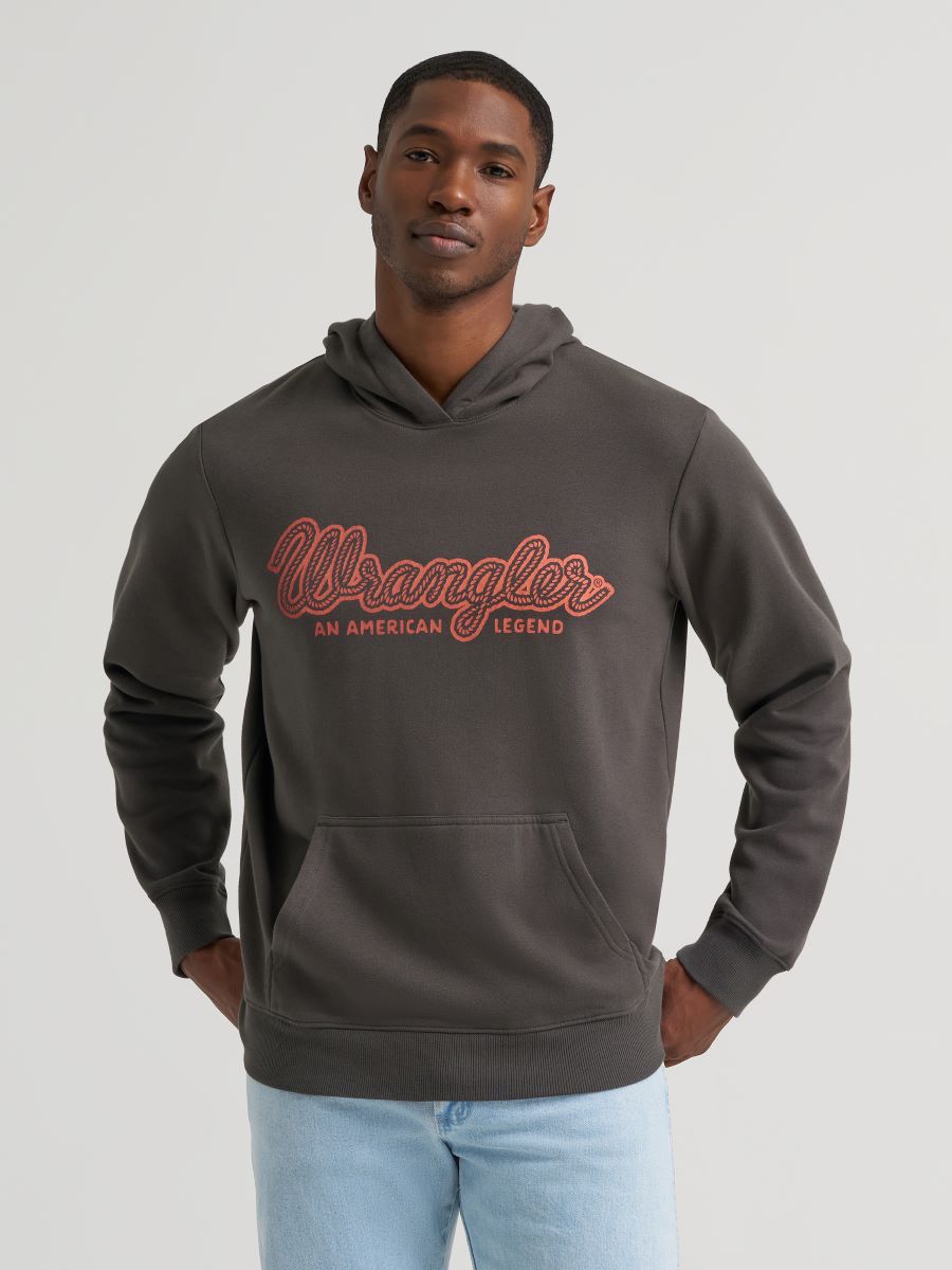 Man wearing a grey Wrangler hoodie and blue jeans on a grey background
