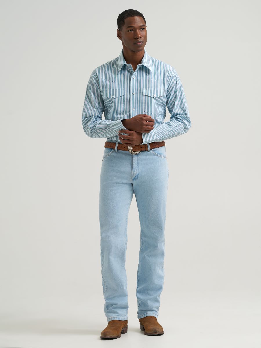 Man wearing a blue striped Wrangler shirt, boots and blue jeans on a grey background