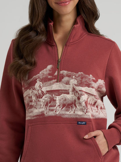 woman wearing a rose colored Wrangler sweater on a grey background