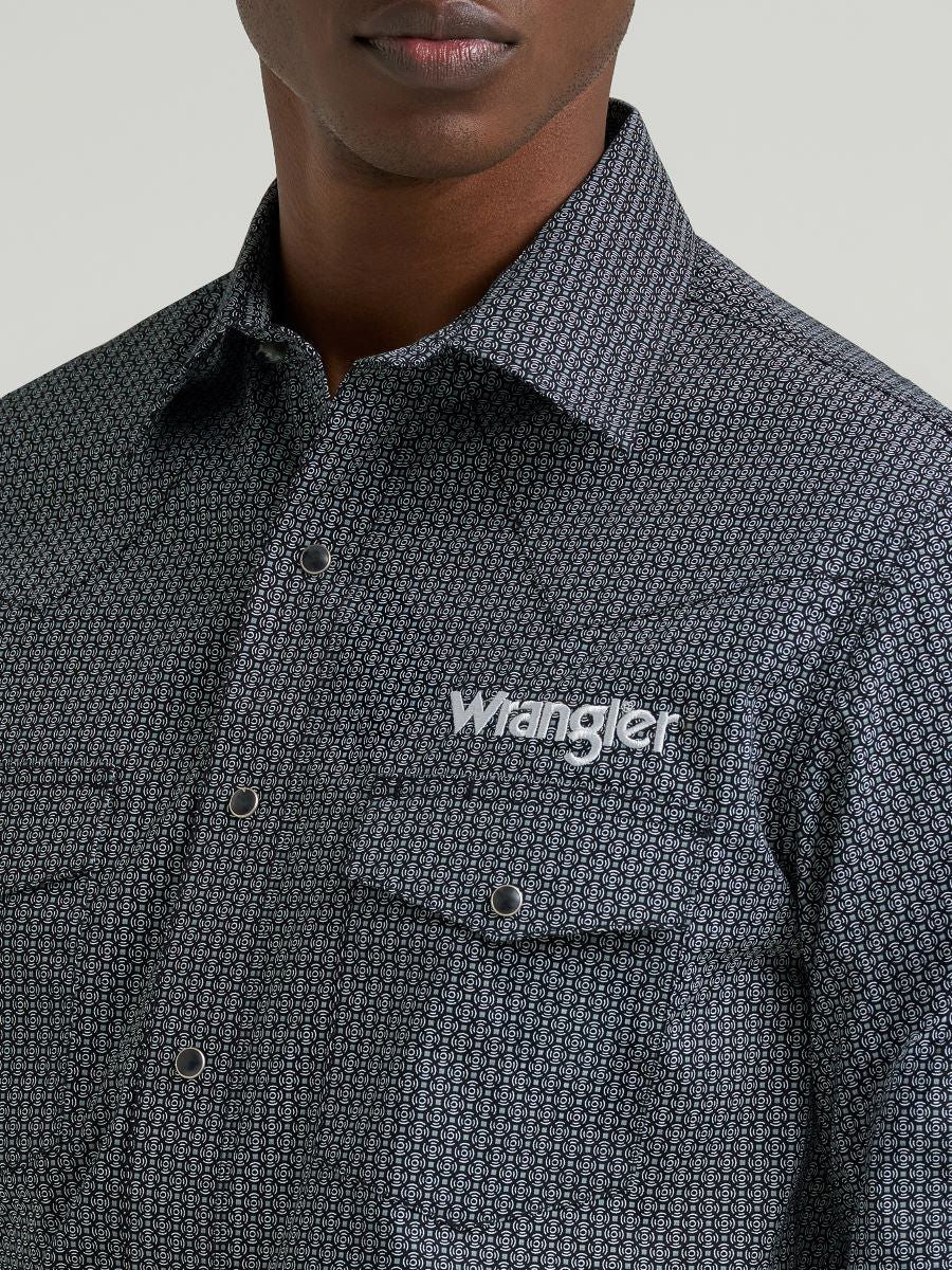 Man wearing a grey printed Wrangler shirt, on a grey background
