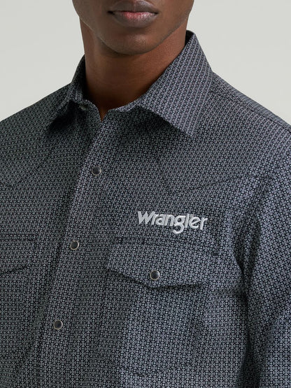 Man wearing a grey printed Wrangler shirt, on a grey background