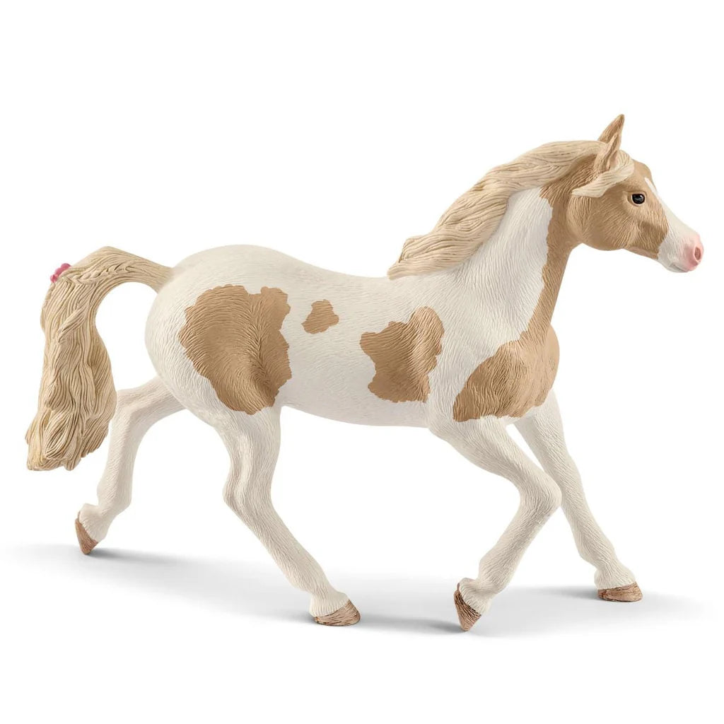 Model Schleich horse with a white body and brown patches on a white background