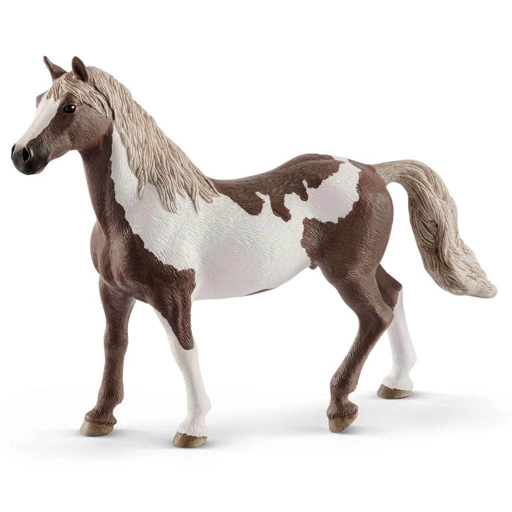 Model Schleich horse with brown and white pattern on a white background