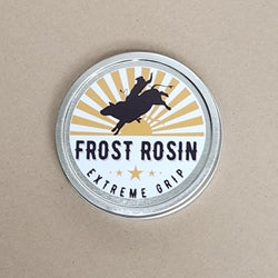 A tin can of Frost Rosin Extreme Grip with a label featuring a silhouette of a person on horseback, with sun and star graphics, and the text 'Extreme Grip'.