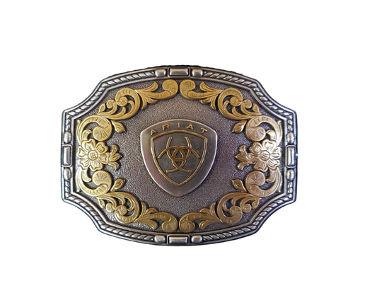 A belt buckle with gunmetal and gold colors, featuring an ariat logo