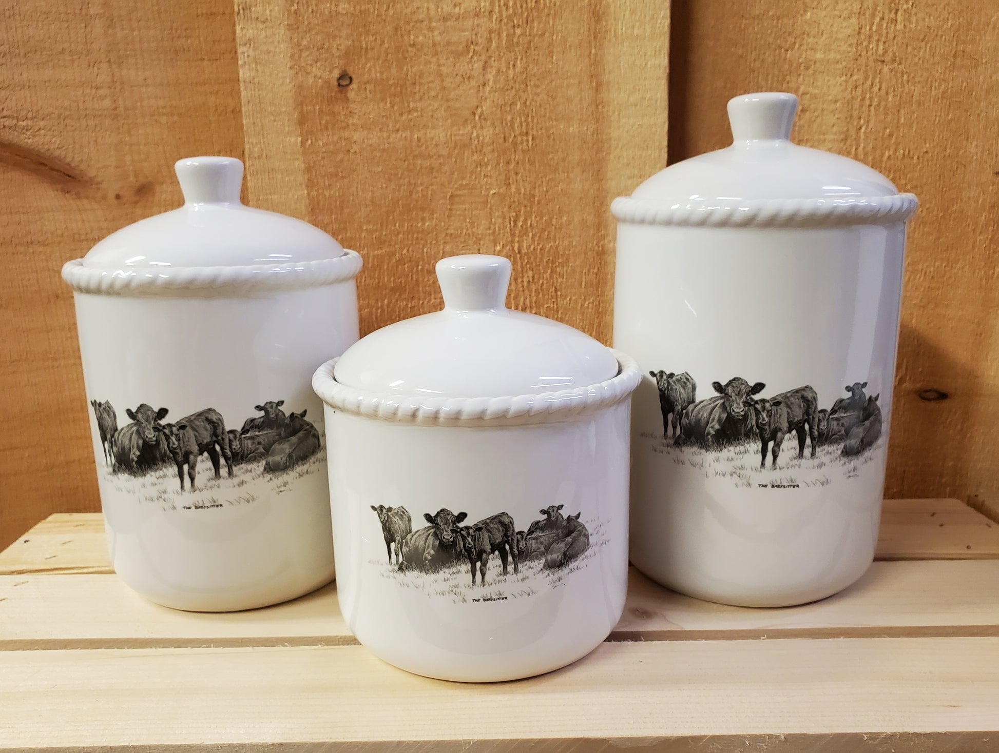 a set of three white ceramic canisters with a western themed black and white design