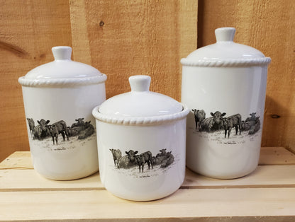 a set of three white ceramic canisters with a western themed black and white design