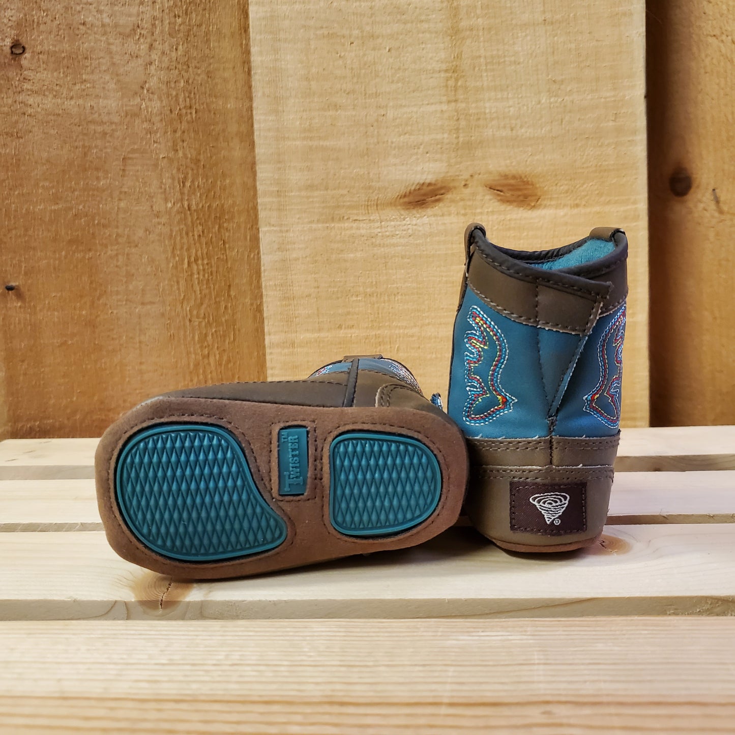Blue and brown baby boots by twister on a wooden backround