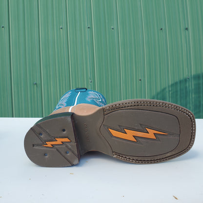 the brown rubber outsole of a kids cowboy boot on a white and green background