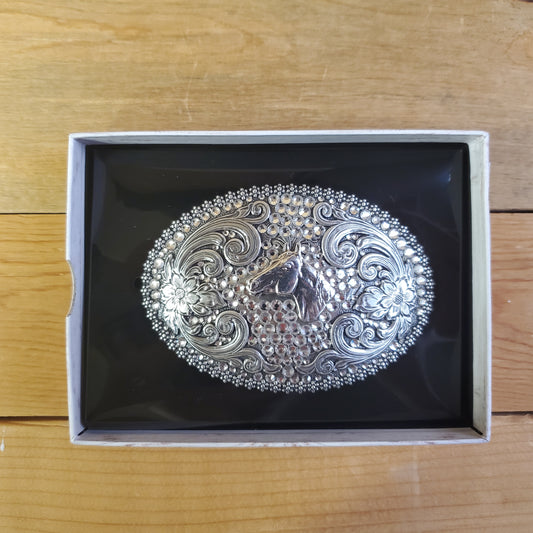 An oval-shaped, antiqued finish belt buckle with crystal embellishments and horse head detail, presented in a box.