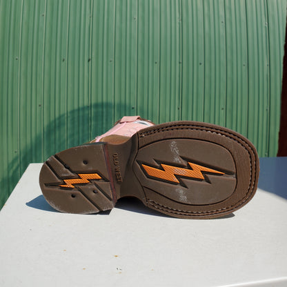 the bottom of a kids boot that is brown and orange on a white and green background