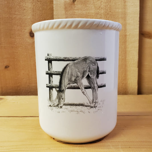 a white ceramic utensil holder with western pencil art featuring a foal eating grass
