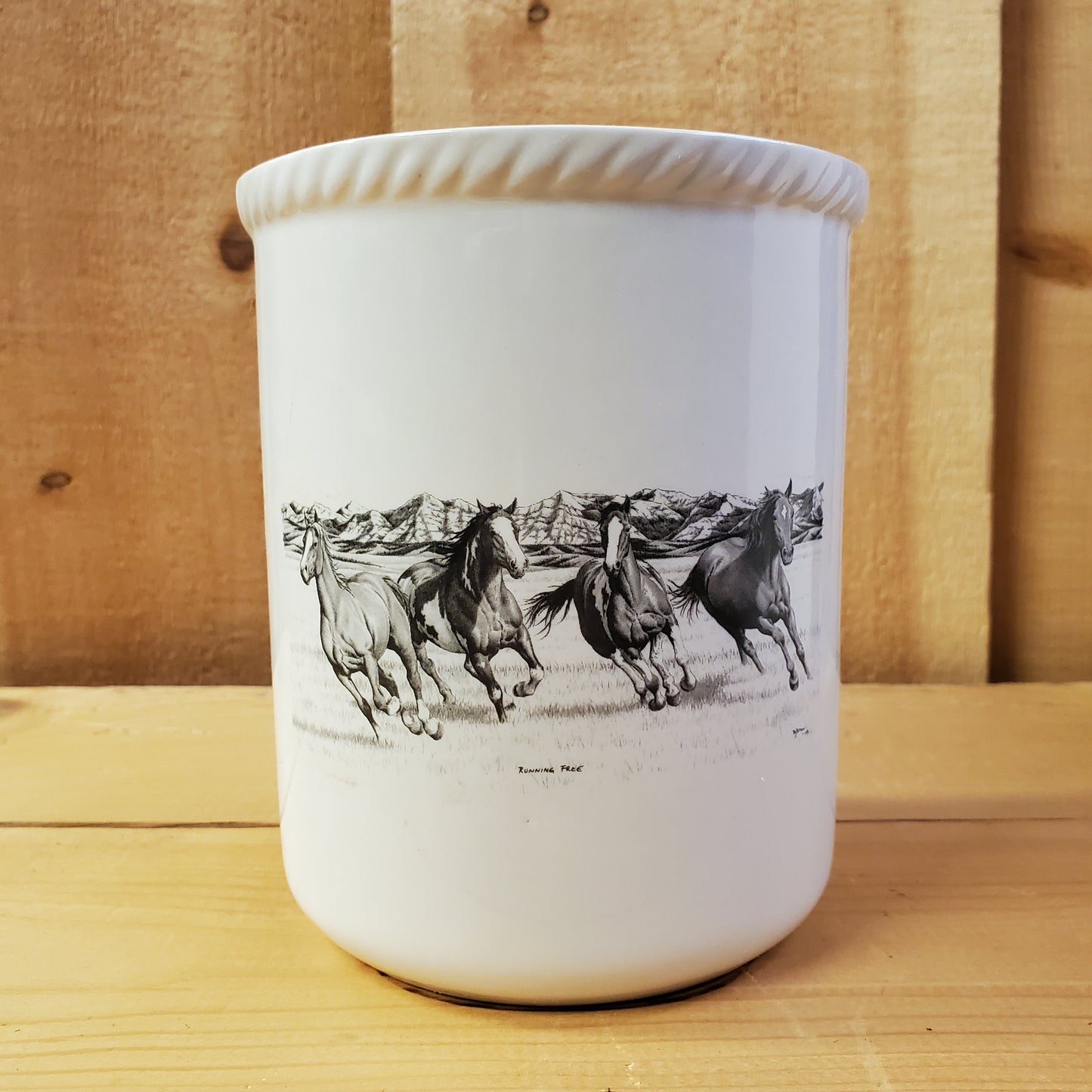 a white ceramic utensil holder with western pencil art featuring running horses