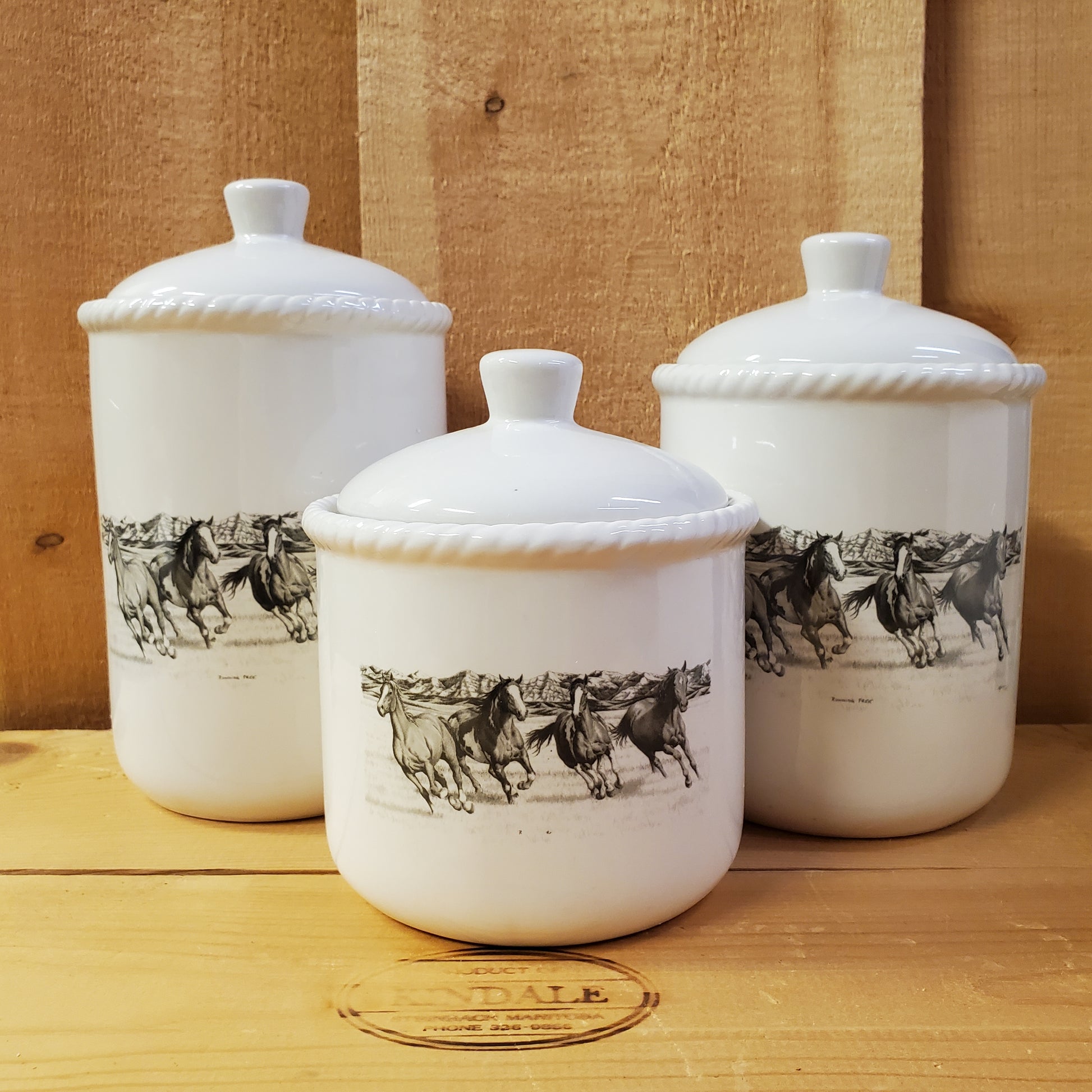 a set of three white ceramic canisters with a western themed black and white design