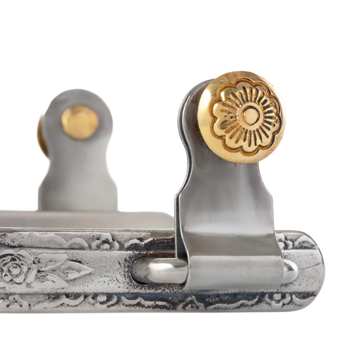Close-up of a spur button with gold and silver design on a white background