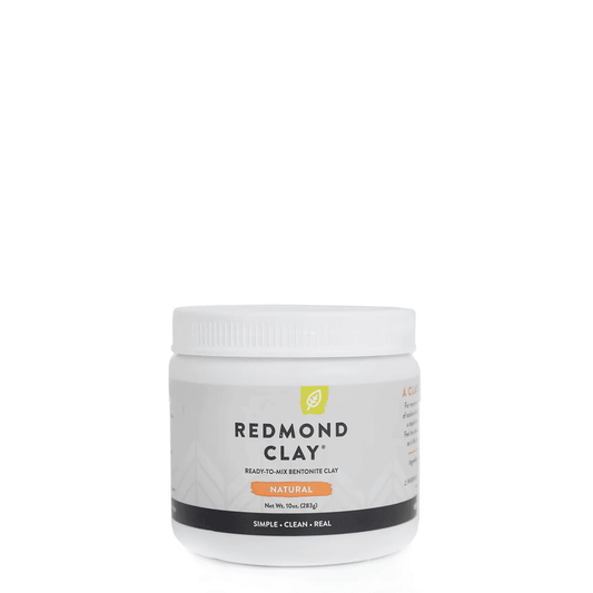 a white tub of redmond clay ready to mix bentonite clay on a white background
