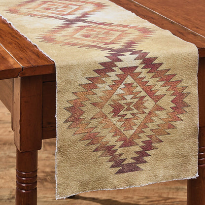 tan colored Table runner with orange axtec pattern on a wooden table