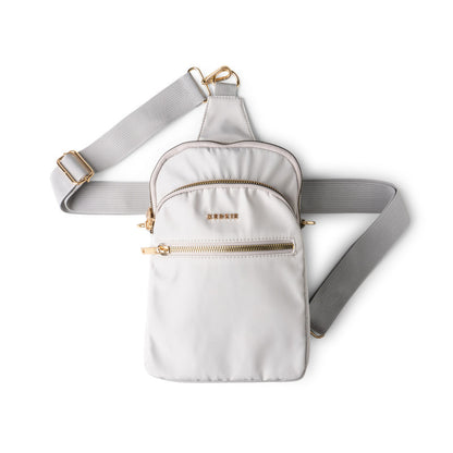 White Kedzie crossbody bag with gold zippers on a white background