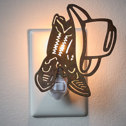 Decorative night light shaped like a cowboy hat and boots on a wall outlet.