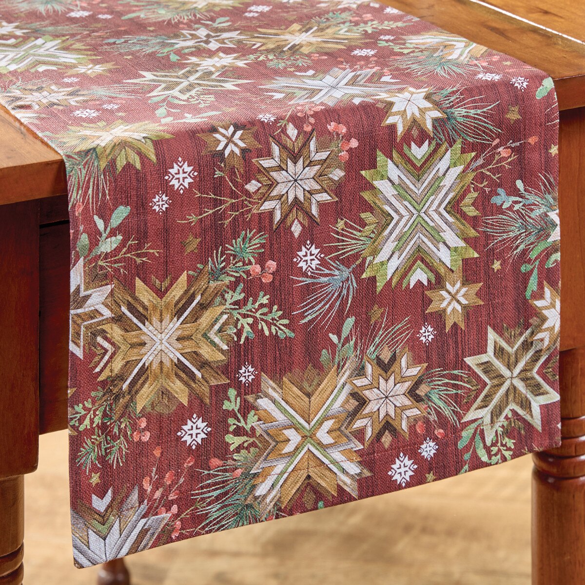 Decorative table runner from Park Designs with snowflake pattern on a wooden table