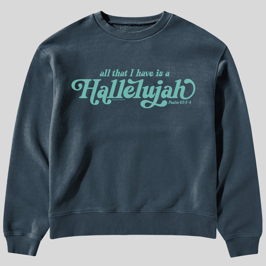 A dark slate blue crewneck sweatshirt from Kerusso featuring the text 'all that I have is a Hallelujah' and 'Psalm 63:3-4' printed in a light teal cursive font across the chest, displayed on a solid gray background.