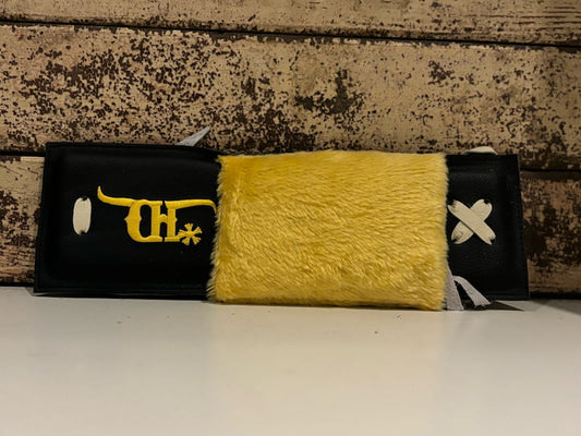 black crooked horn bull rope pad with a yellow shearling cover on a distressed background