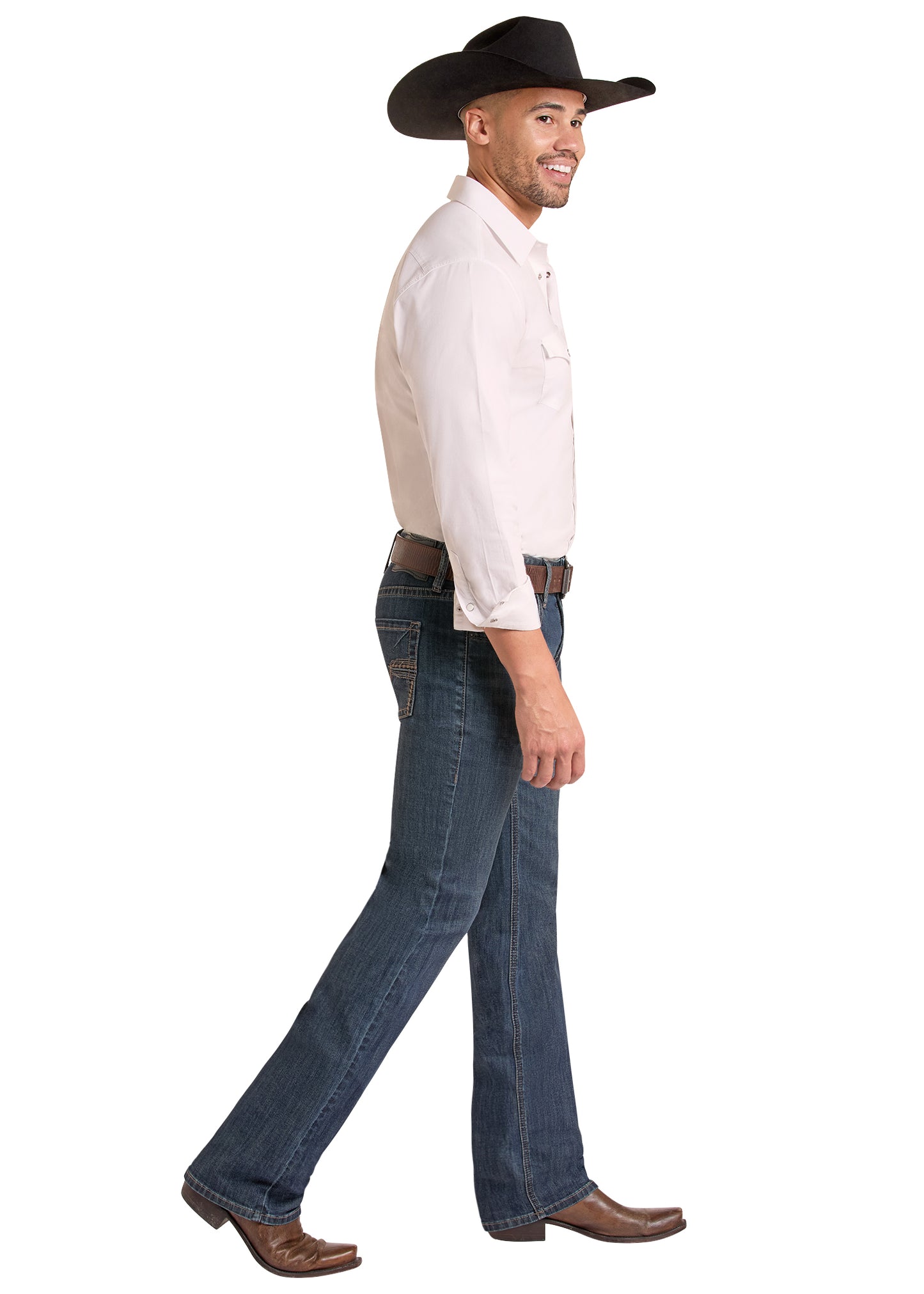 A man in profile wearing a black cowboy hat, a light-colored long-sleeve button-up shirt, dark blue jeans, and brown cowboy boots, walking against a plain white background.