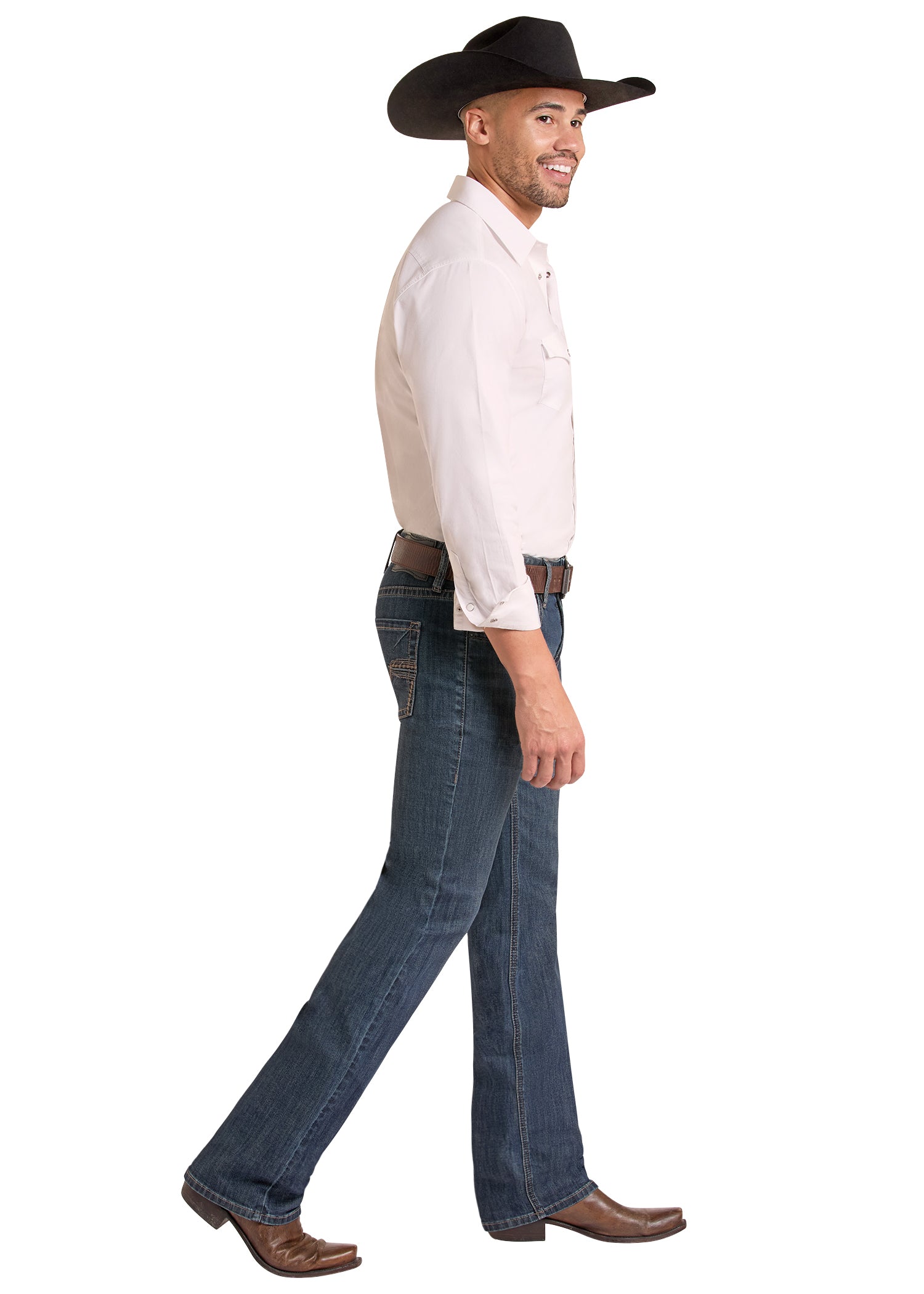 A man in profile wearing a black cowboy hat, a light-colored long-sleeve button-up shirt, dark blue jeans, and brown cowboy boots, walking against a plain white background.