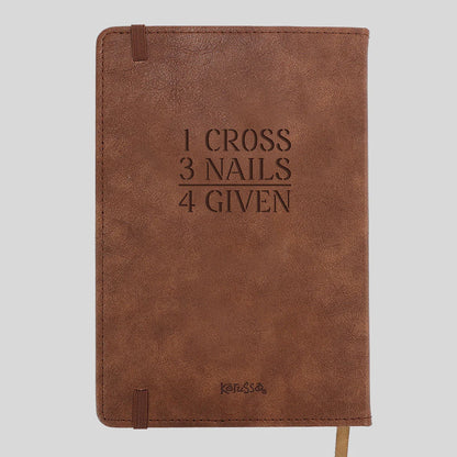 A brown faux-leather notebook with the embossed text '1 CROSS 3 NAILS 4 GIVEN' on the front cover, featuring a matching brown elastic closure tab and a small 'Kerusso' logo near the bottom, shown against a solid light gray background.
