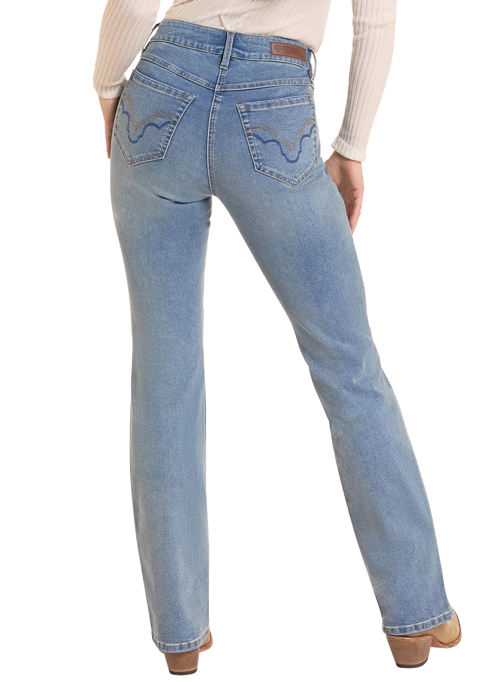 Rear view of a person wearing light blue straight-leg Rock&Roll Denim jeans with decorative stitching on the back pockets, paired with a cream ribbed long-sleeve top and brown shoes, against a white background.