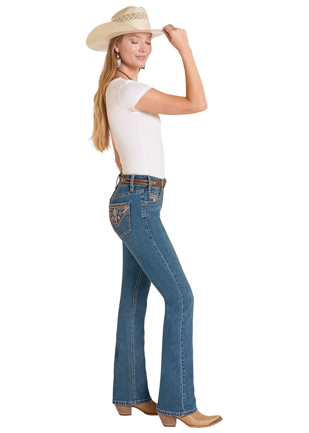 Woman wearing blue Rock&Roll Denim jeans with a decorative patch, white shirt, and beige cowboy hat on a white background