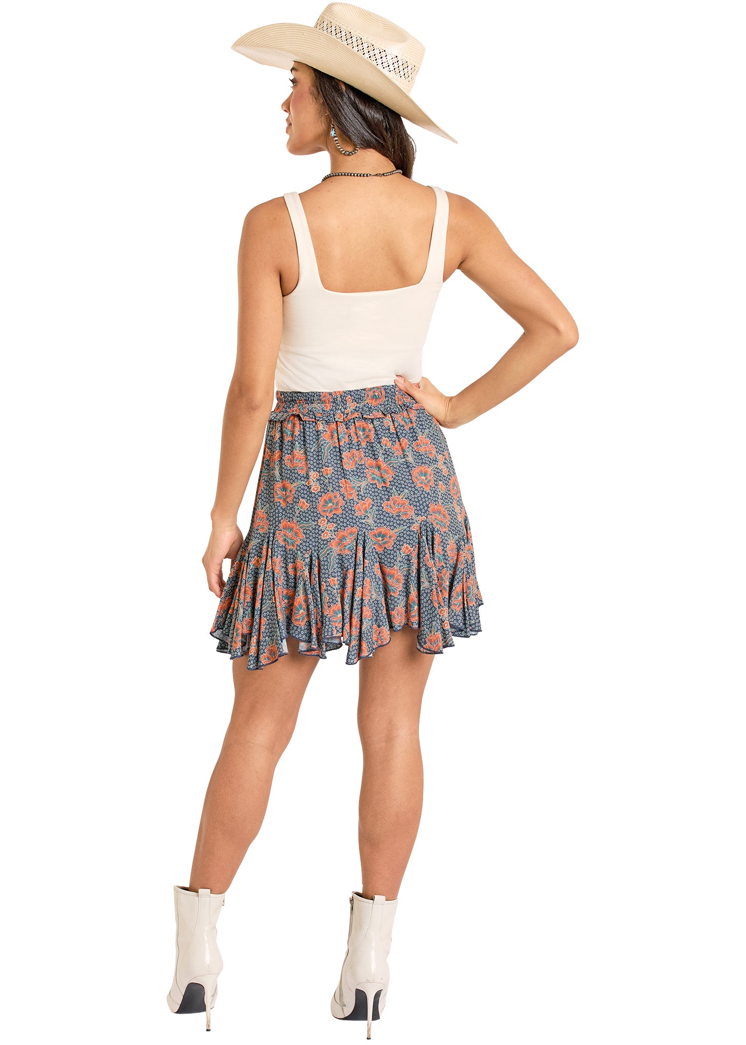 girl wearing a blue and orange Panhandle Slim skirt, cowboy boots and hat and white top on a white background