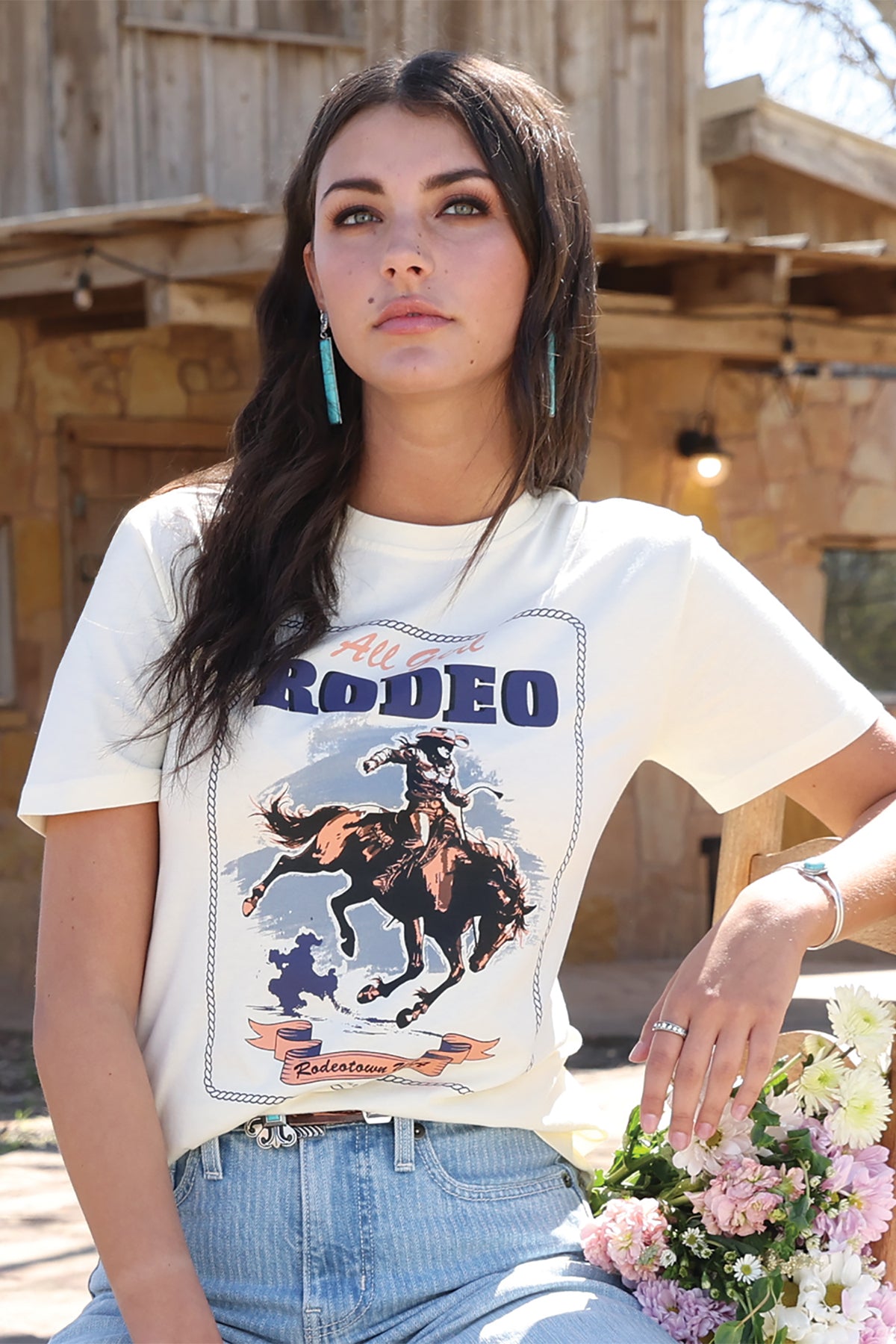 Woman wearing a cruel denim t-shirt with a rodeo graphic design outdoors.