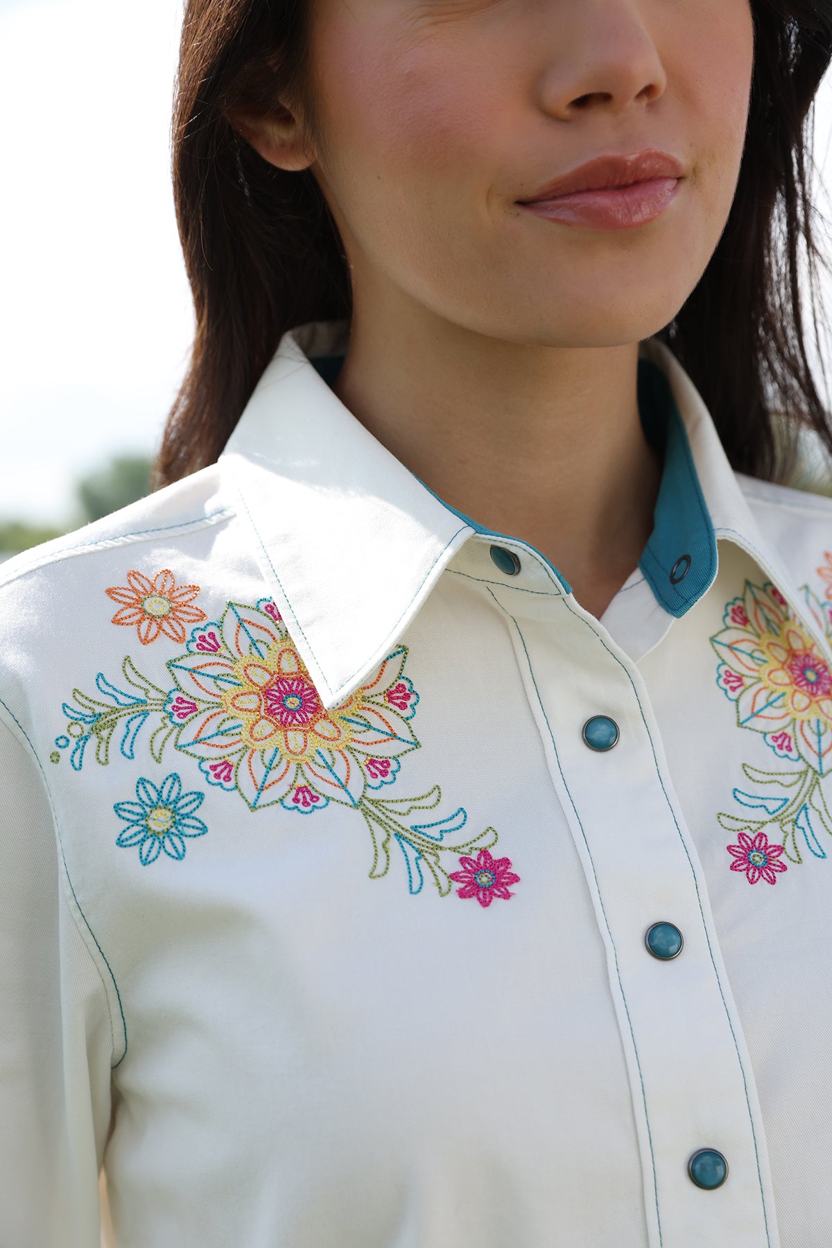 Woman wearing Cinch shirt with flowers on it