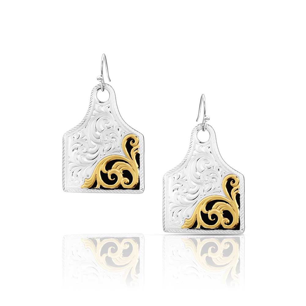 Pair of Montana Silversmiths earrings with gold and black designs on a white background