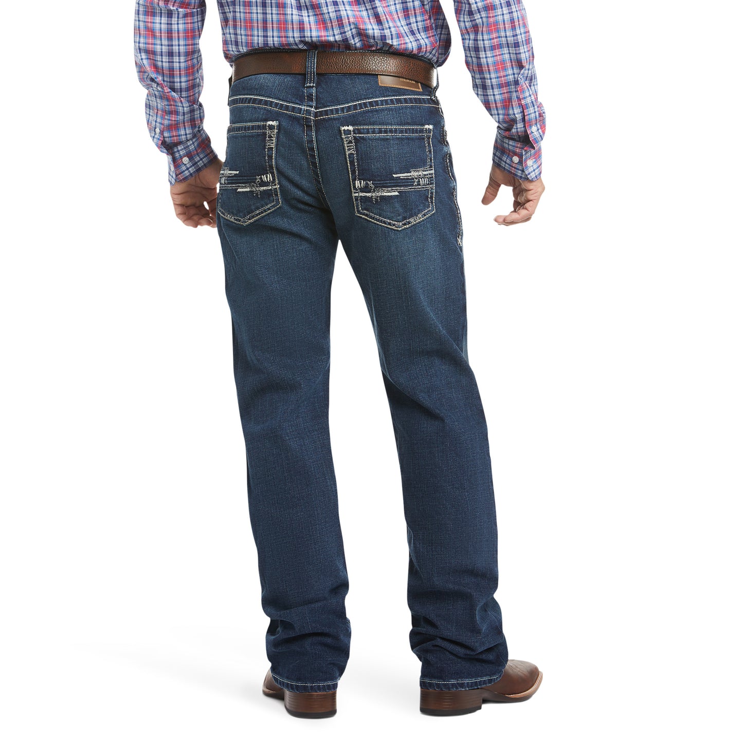 man wearing denim Ariat jeans with a brown belt and plaid shirt on a white background