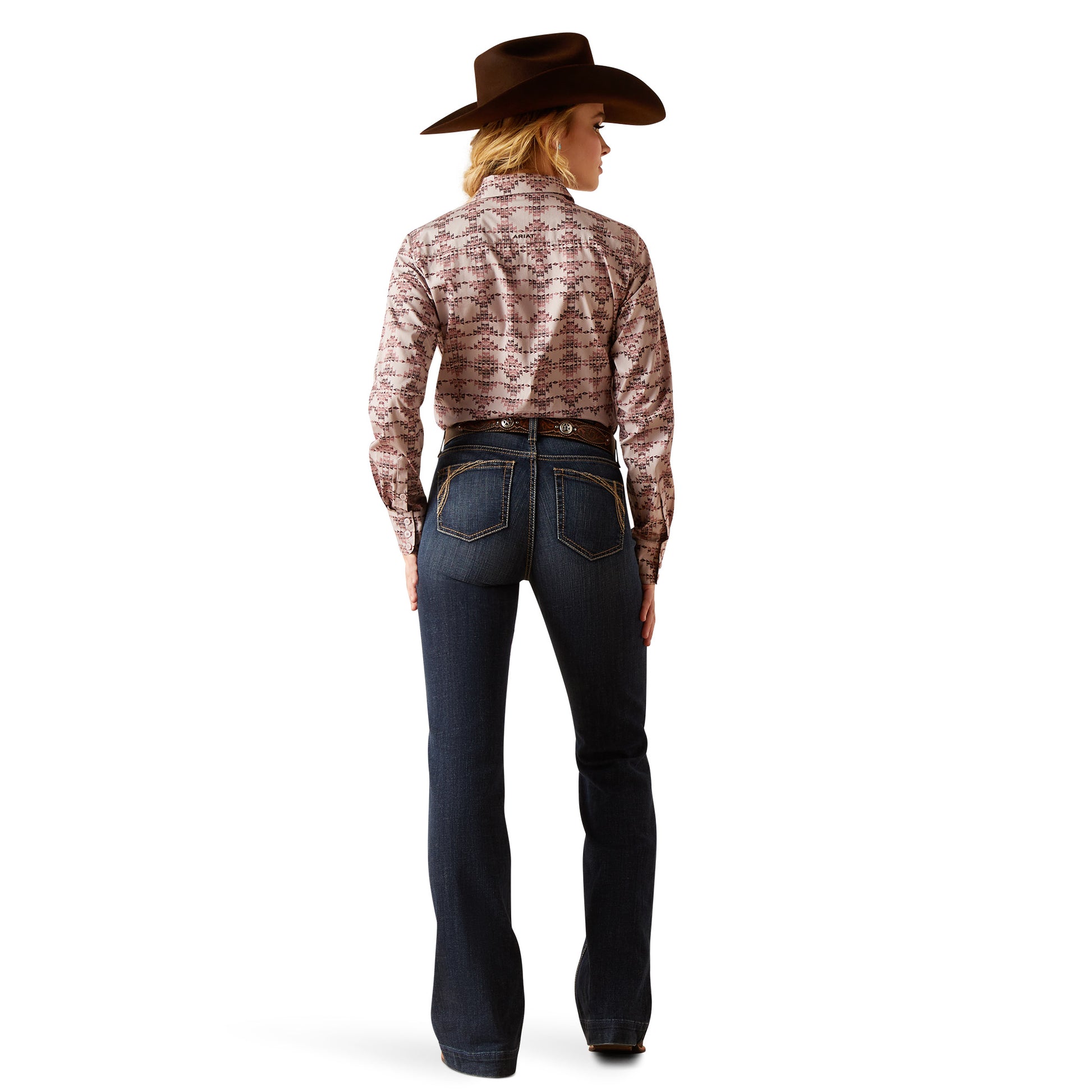 Person wearing a patterned shirt, dark jeans, and a cowboy hat on a white background