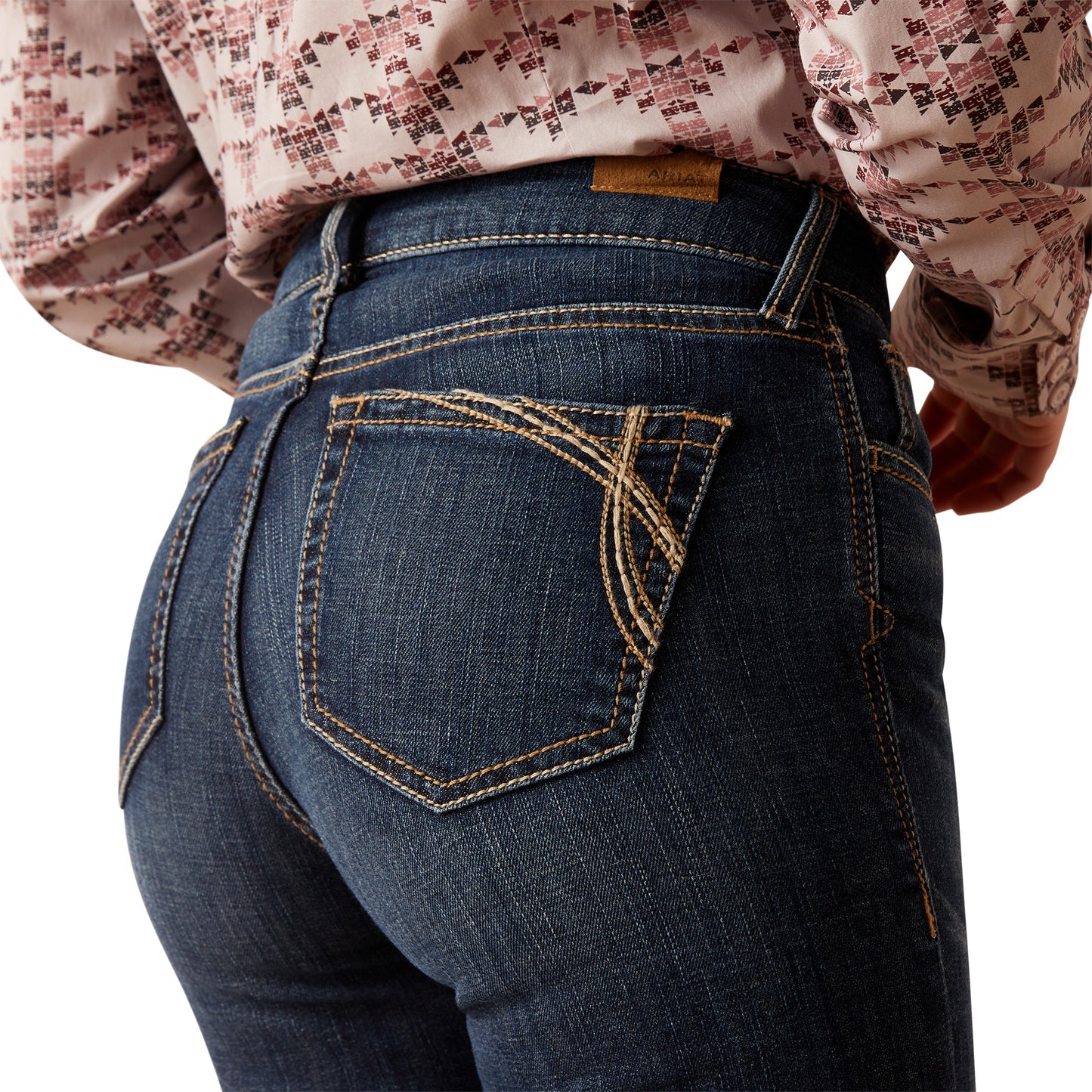 Close-up of blue jeans with a decorative back pocket on a white background