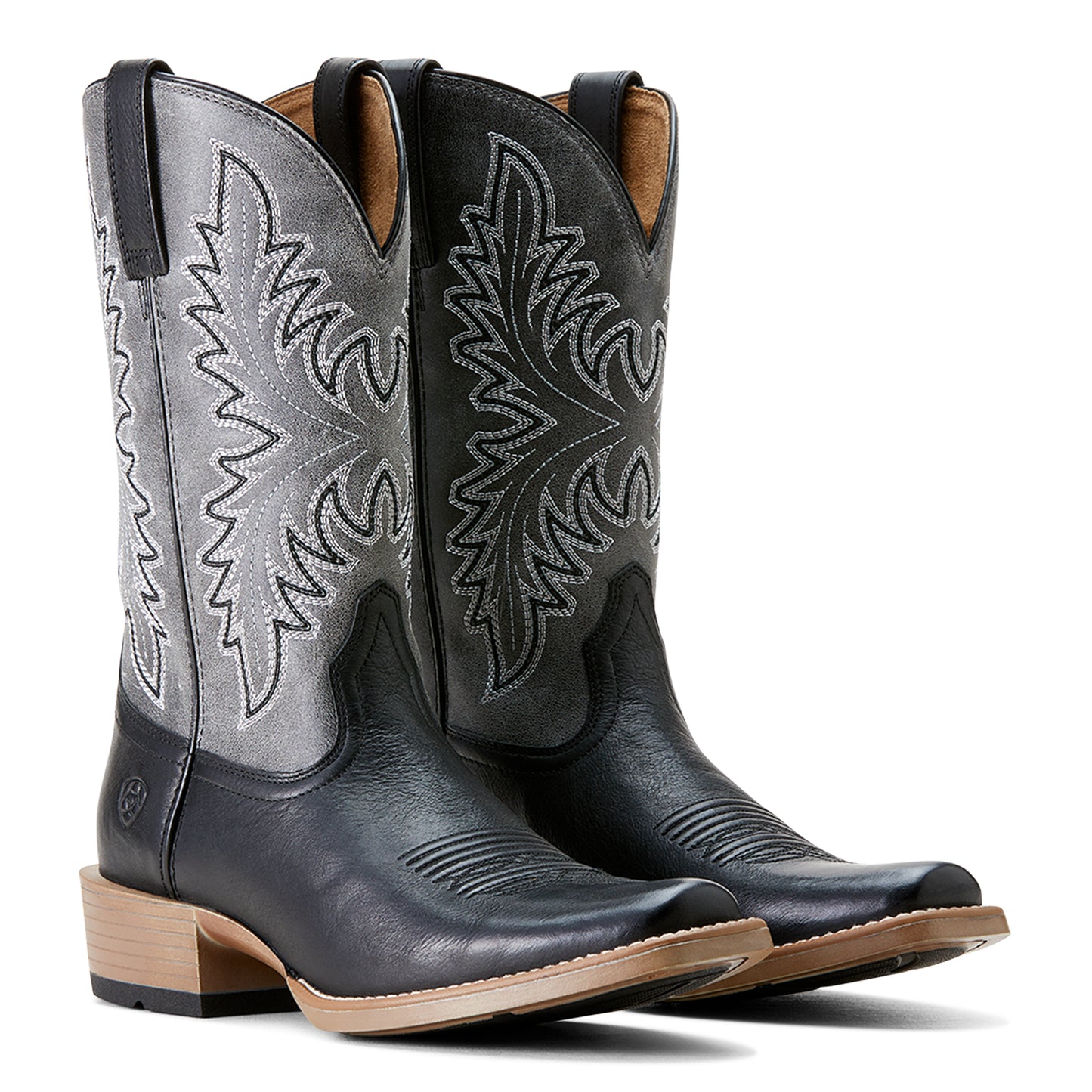 a pair of black and grey cowboy boots by ariat on a white background