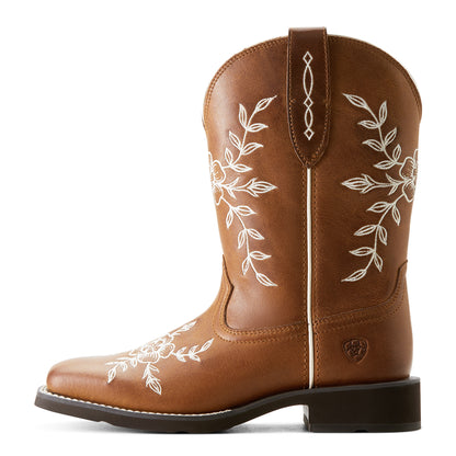a side view of a brown cowboy boot with white floral embroidery with an ariat logo