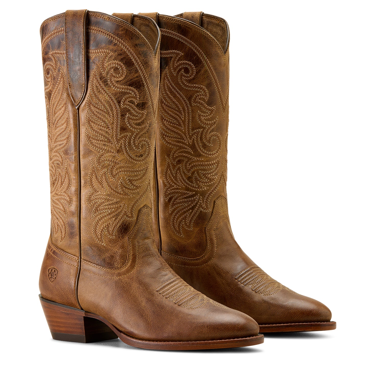Pair of brown cowboy boots with intricate designs on a white background