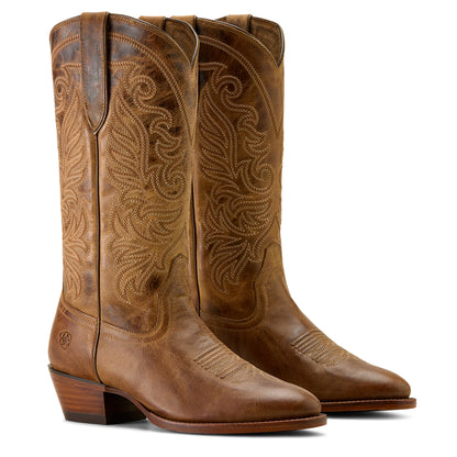 Pair of brown cowboy boots with intricate designs on a white background