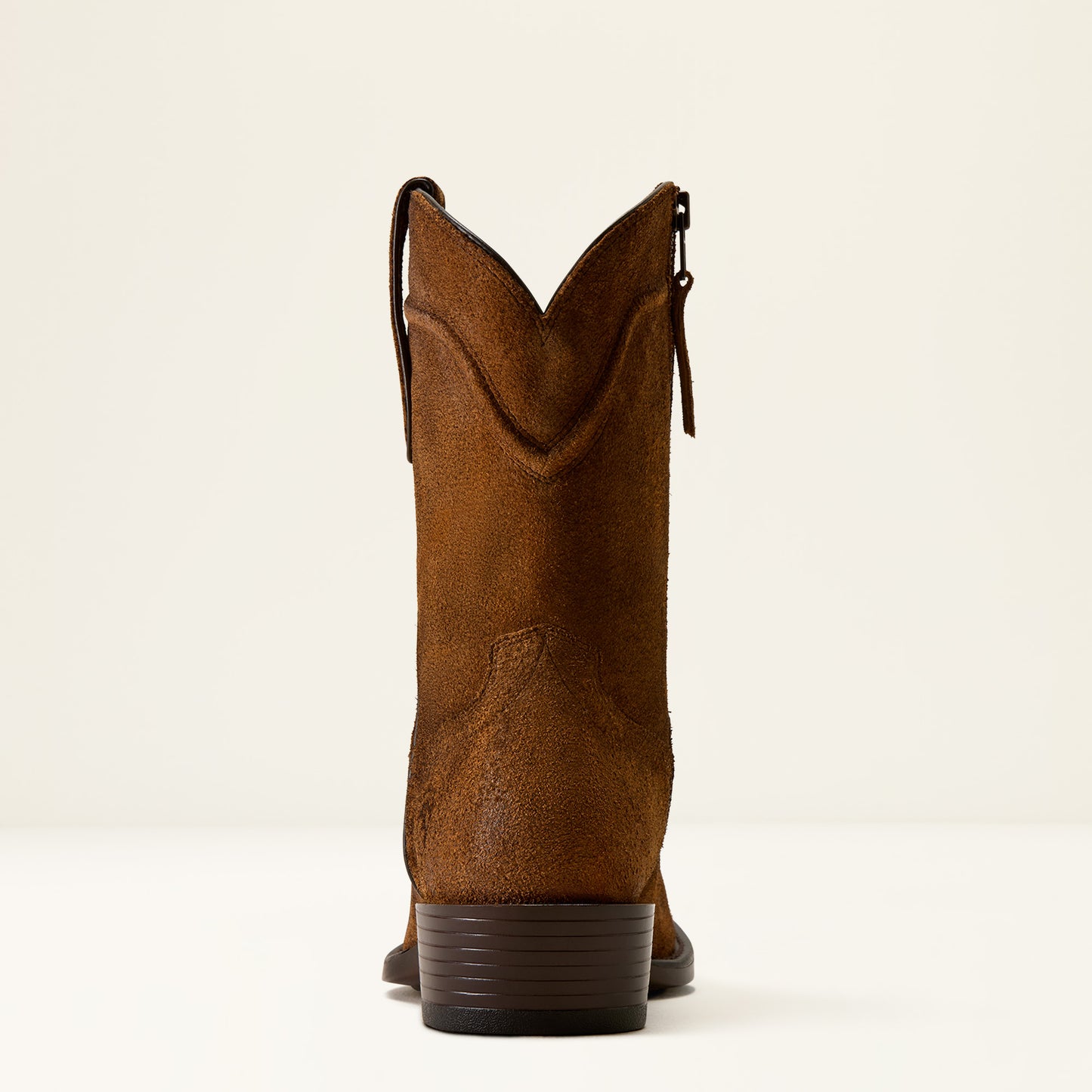 A single brown suede cowboy boot shown from the back, featuring a side zipper and a stacked dark brown heel, set against a plain off-white background.