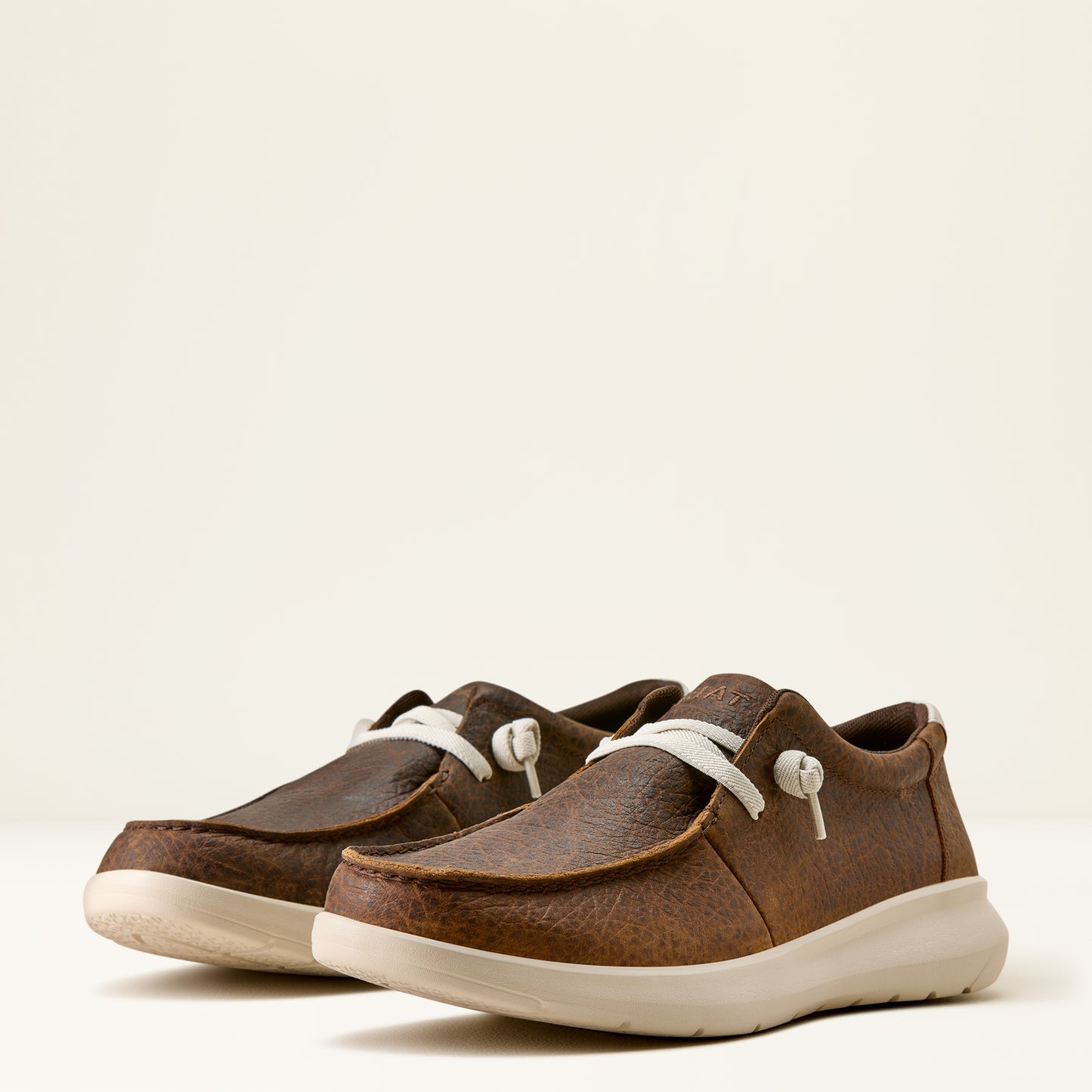 a pair of men's brown elephant print hilo shoes by ariat on an off white background