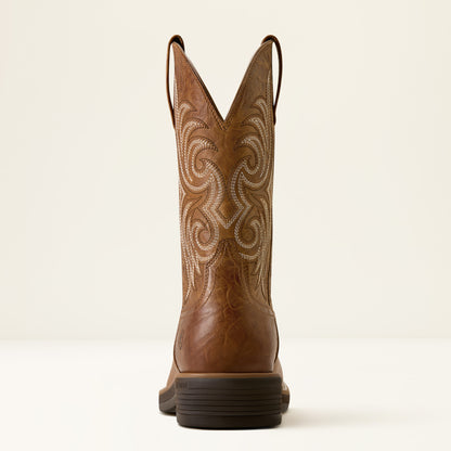 the back of a tan brown wide squre toe cowboy boot by ariat on a off white background