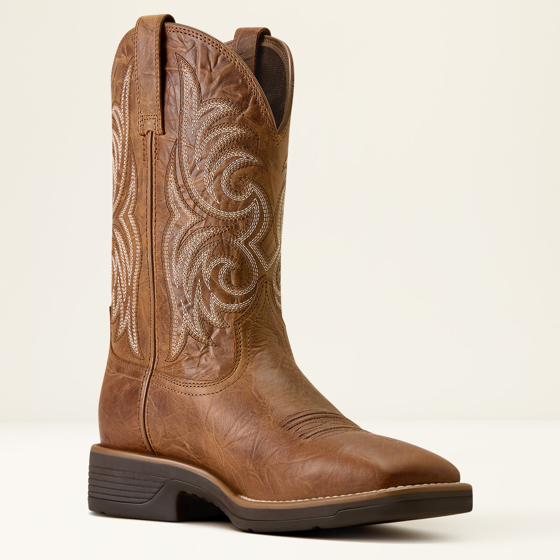 a tan brown wide squre toe cowboy boot by ariat on a off white background