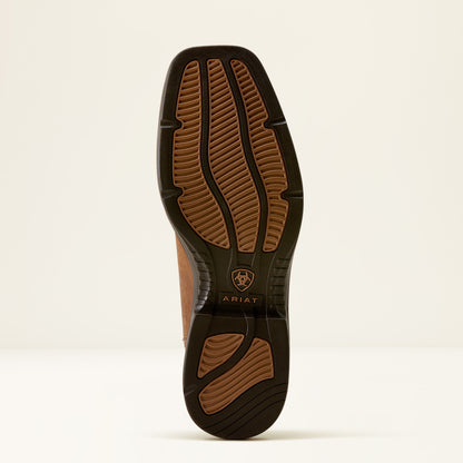 The outsole of a brown leather boot with a black rubber tread, featuring the Ariat logo and brand name.