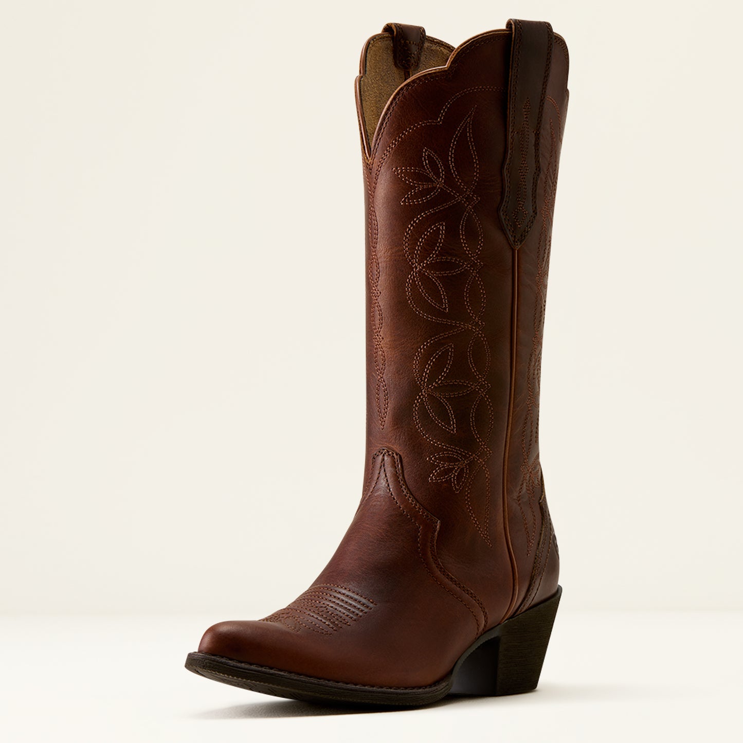 A single brown leather cowboy boot with decorative western-style stitching and a low block heel, photographed against a clean off-white background.