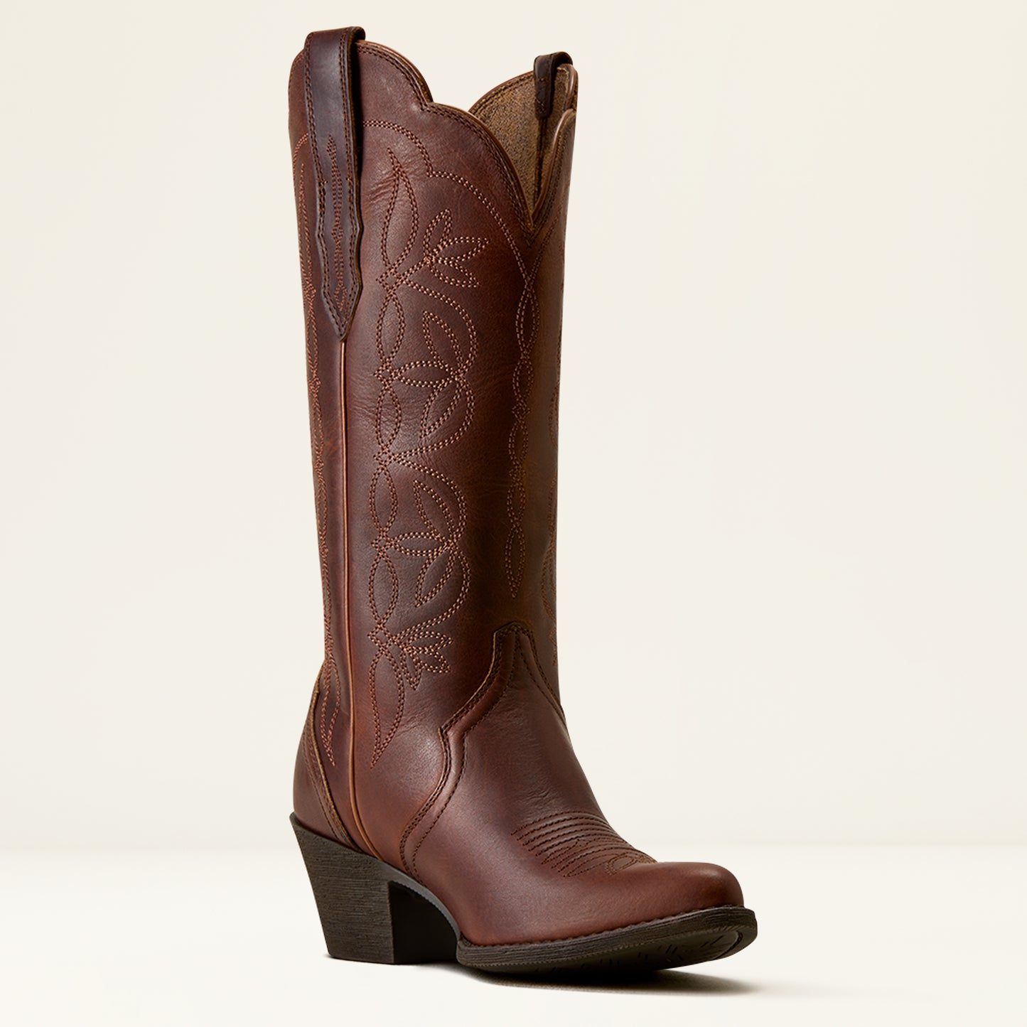 A single brown leather cowboy boot with decorative stitching, a low block heel, and a square toe, photographed against a clean off-white background.